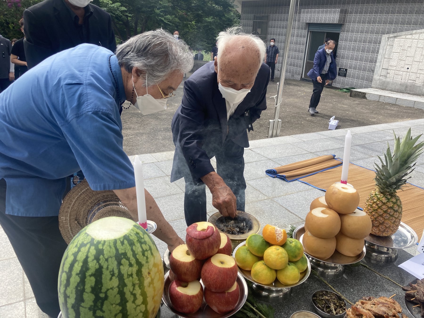 은발의 유족들이 위령제단 앞에서 분향하고 있다.