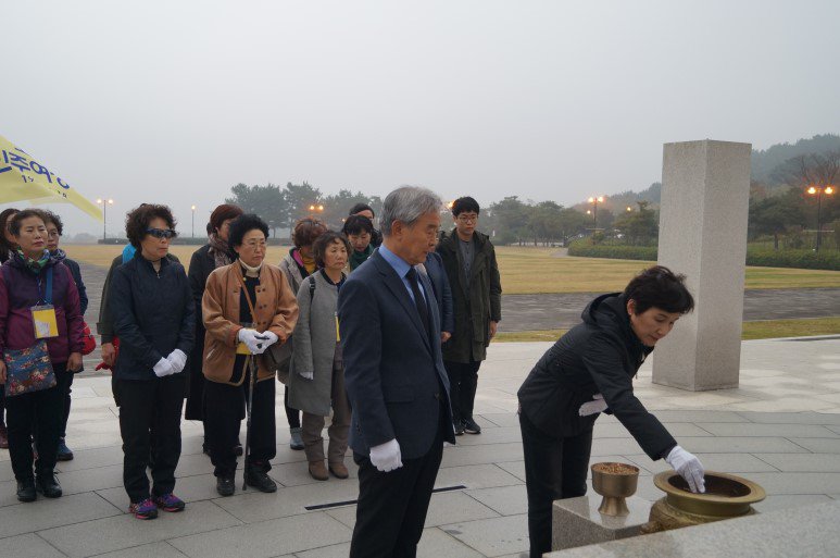 '제주4.3 평화재단' 이문교 이사장의 안내로 '오월 민주여성회' 이윤정 회장이 분향을 하고있다