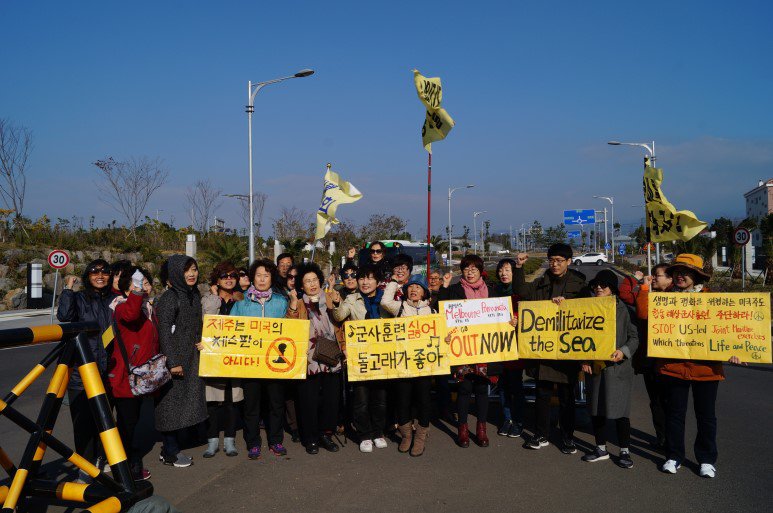 오월민주여성회 회원들이 해군기지 앞에서 피켓을 들고 시위를 하고 있다.