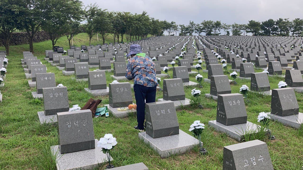 가족의 이름이 새겨진 표석에 술을 올리는 모습.